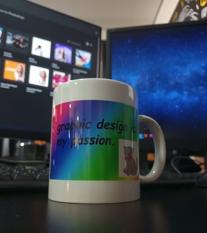 Caneca escrita graphic design is my passion diante de dois monitores