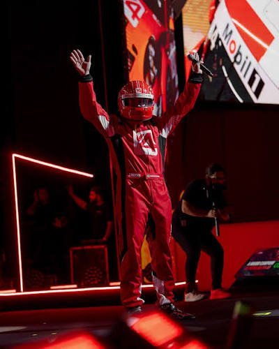 Entrada de palco com macacão e capacete de corrida no evento Looking Ahead, da V4 Company