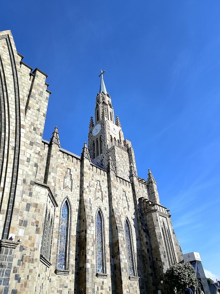 Torre de pedra de uma catedral contra o céu azul, na serra gaúcha