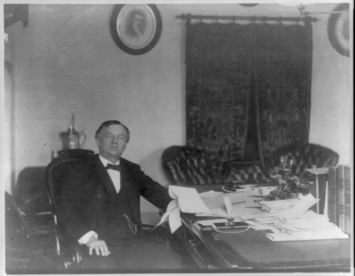 Retrato fotográfico em preto e branco de John Wanamaker sentado à mesa de trabalho.